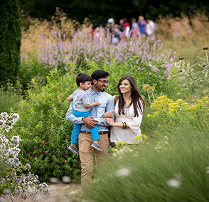 Image shows a young Asian family walking through the gardens at The Trentham Estate